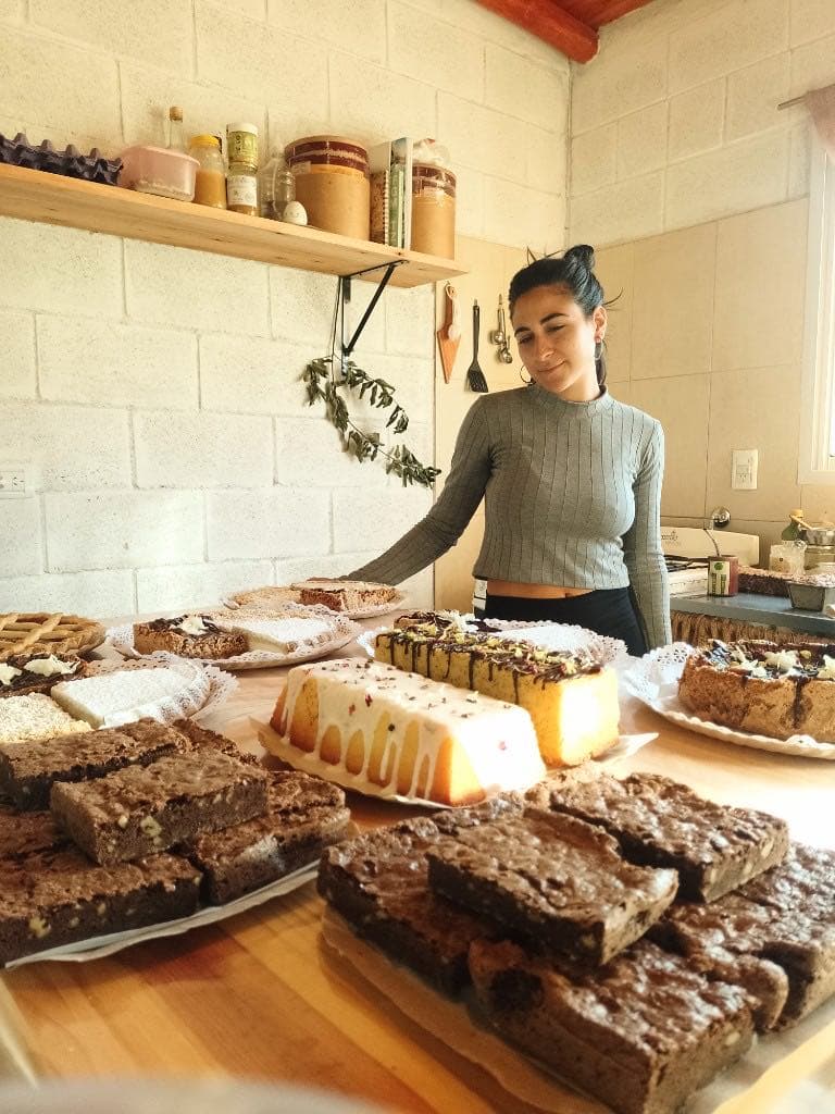 Pastelera junto a tortas y brownies en la cocina